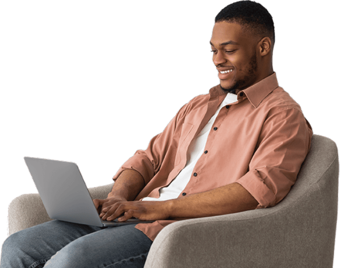 Homem sorrindo sentado com um notebook no seu colo